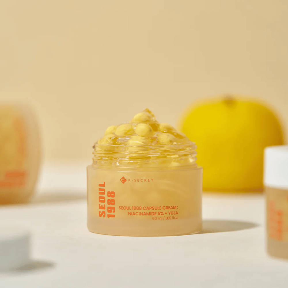 Open pot met gele capsules naast een gehalveerde yuja-vrucht die de vitamine C-rijke formule benadrukt.