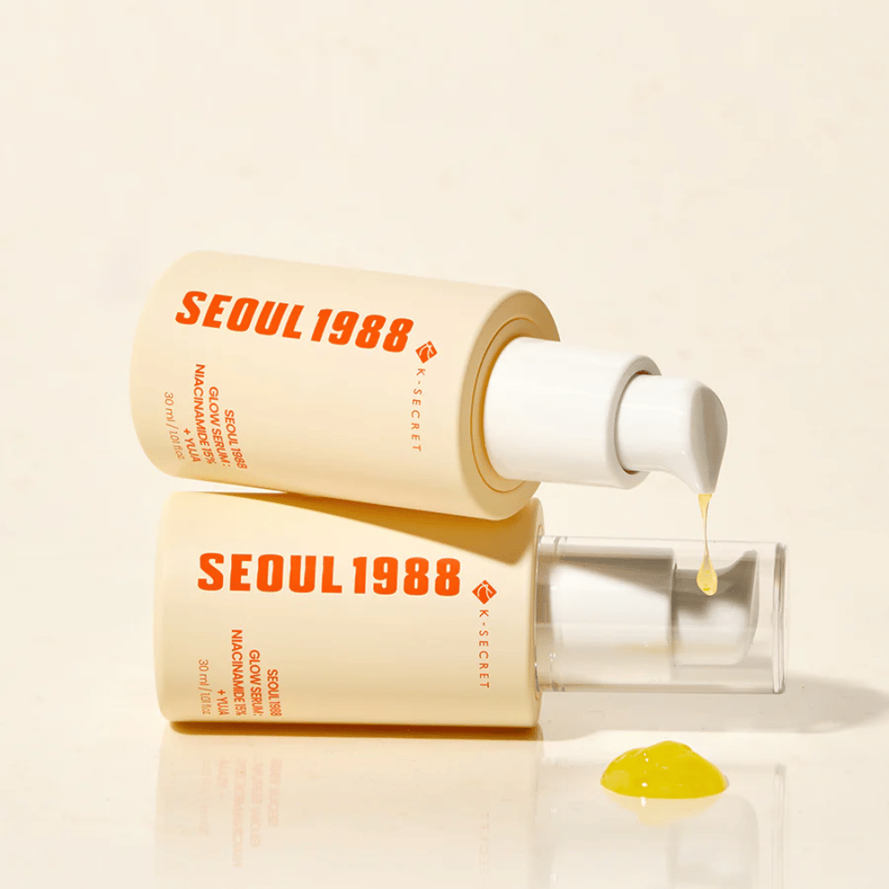 Twee flessen Seoul 1988 Glow Serum liggend en staand, met geel serum dat uit de pomp druppelt.