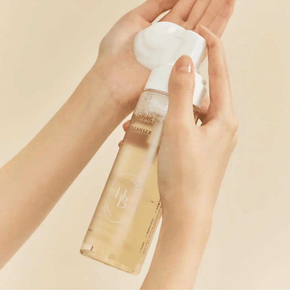Heveblue Salmon Caring Centella Bubble Cleanser wordt in de hand gebruikt – milde Koreaanse bubble cleanser die een luchtig schuim creëert en helpt de huid te reinigen zonder uit te drogen.
