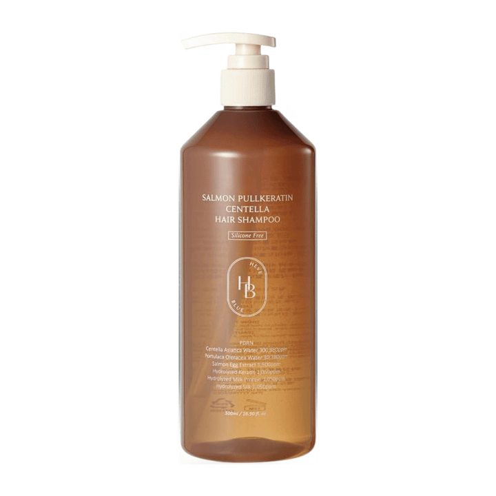 Heveblue Salmon Pullkeratin Centella Hair Shampoo in een transparante bruine pompflacon tegen een lichte achtergrond. Shampoo met centella, zalmextract en keratine die helpt het haar te reinigen en te verzorgen.