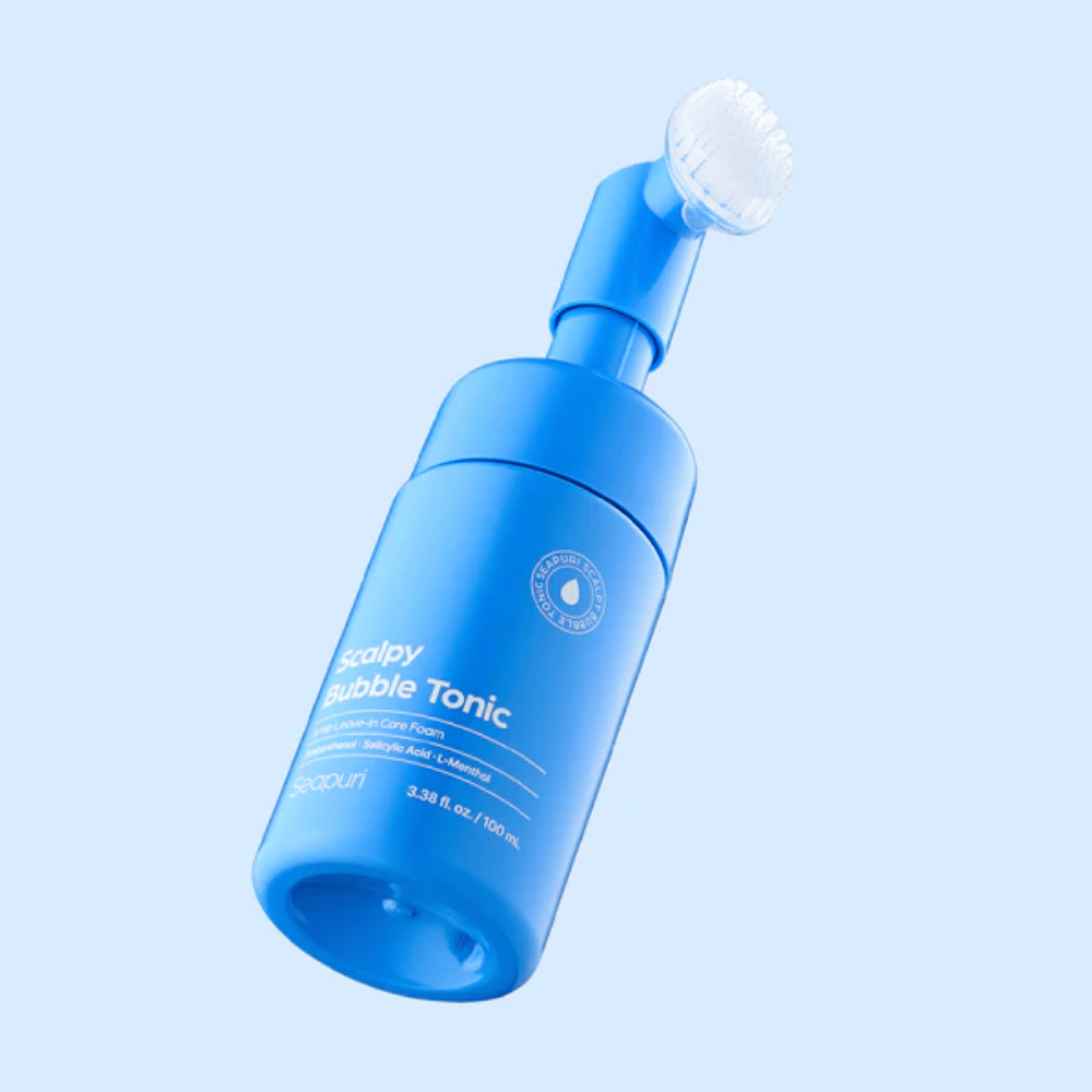 Stijlvolle productafbeelding van Seapuri Scalpy Bubble Tonic tegen een lichtblauwe achtergrond die het moderne ontwerp en de unieke borstelkap voor hoofdhuidverzorging benadrukt.