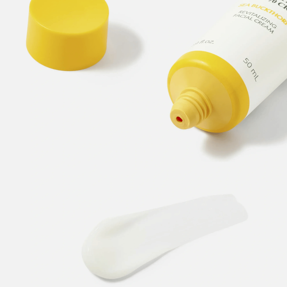 1. Purito SEOUL Sea Buckthorn Vital 70 Cream – close-up van de lichte witte textuur van de gezichtscrème naast een open tube met gele dop