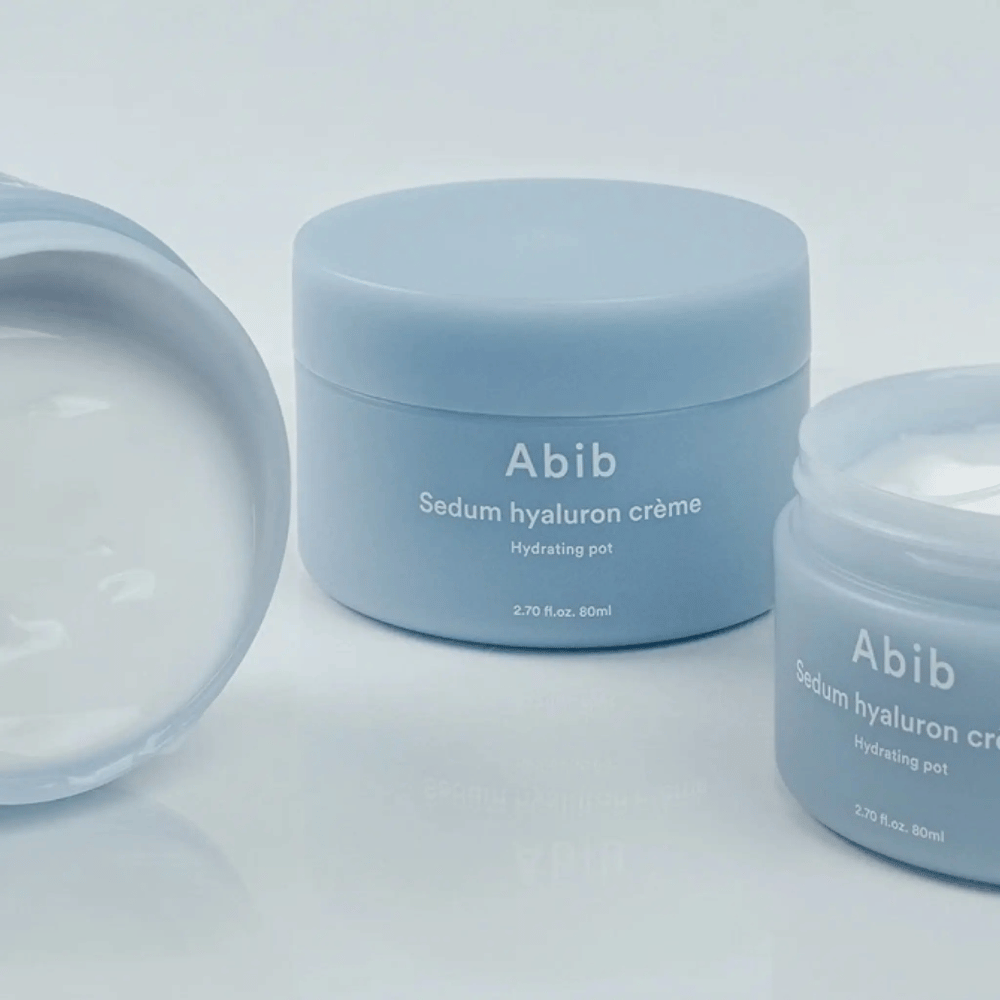 Drie potjes van Abib Sedum Hyaluron Crème Hydrating Pot 80 ml in lichtblauw minimalistisch design, waarvan een geopend potje de romige witte textuur laat zien.