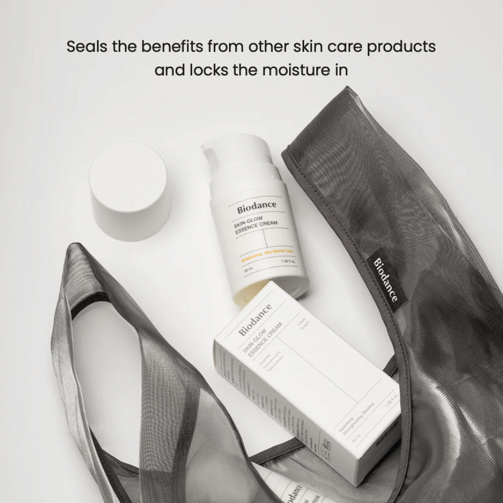 Biodance Skin-Glow Essence Cream staand in focus samen met de productverpakking en een zwarte doorzichtige toilettas, met tekst erboven die het vermogen van de crème benadrukt om vocht in te kapselen en het effect van andere huidverzorgingsproducten te versterken.