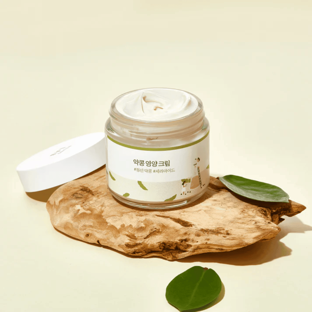 Mixsoon Soybean Nourishing Cream i öppen burk på ett trästycke med gröna blad. En näringsrik kräm med fermenterade sojabönor och ceramider.
