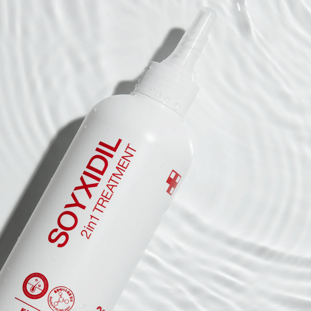 Fles van Medicube Soyxidil 2in1 Treatment ligt op een golvend wateroppervlak, wat staat voor hydraterende en verfrissende verzorging.
