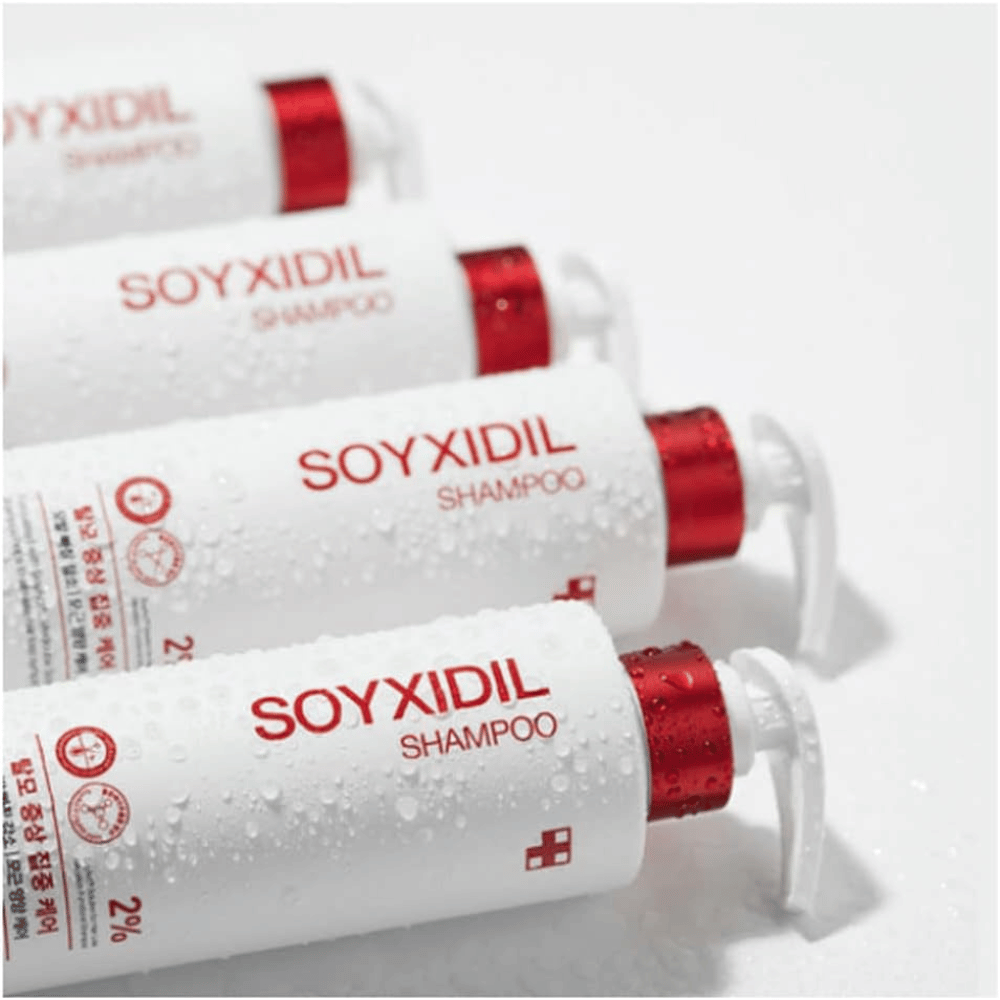 Meerdere flessen van Medicube Soyxidil Shampoo liggen op een rij met waterdruppels - toont het frisse en verzorgende gevoel van het product.