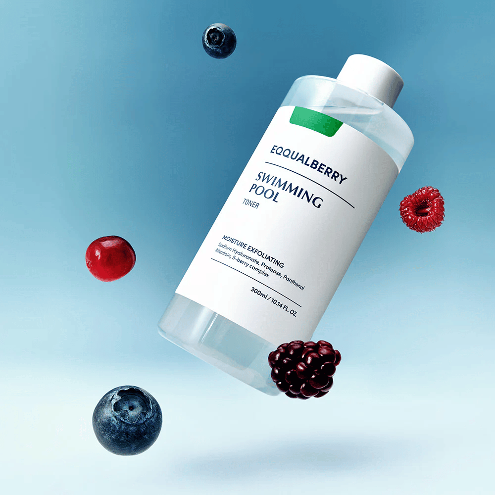 Equalberry Swimming Pool Toner in een stijlvol flesje zwevend tegen een blauwe achtergrond, omgeven door verse bessen zoals bosbessen, frambozen en bramen.