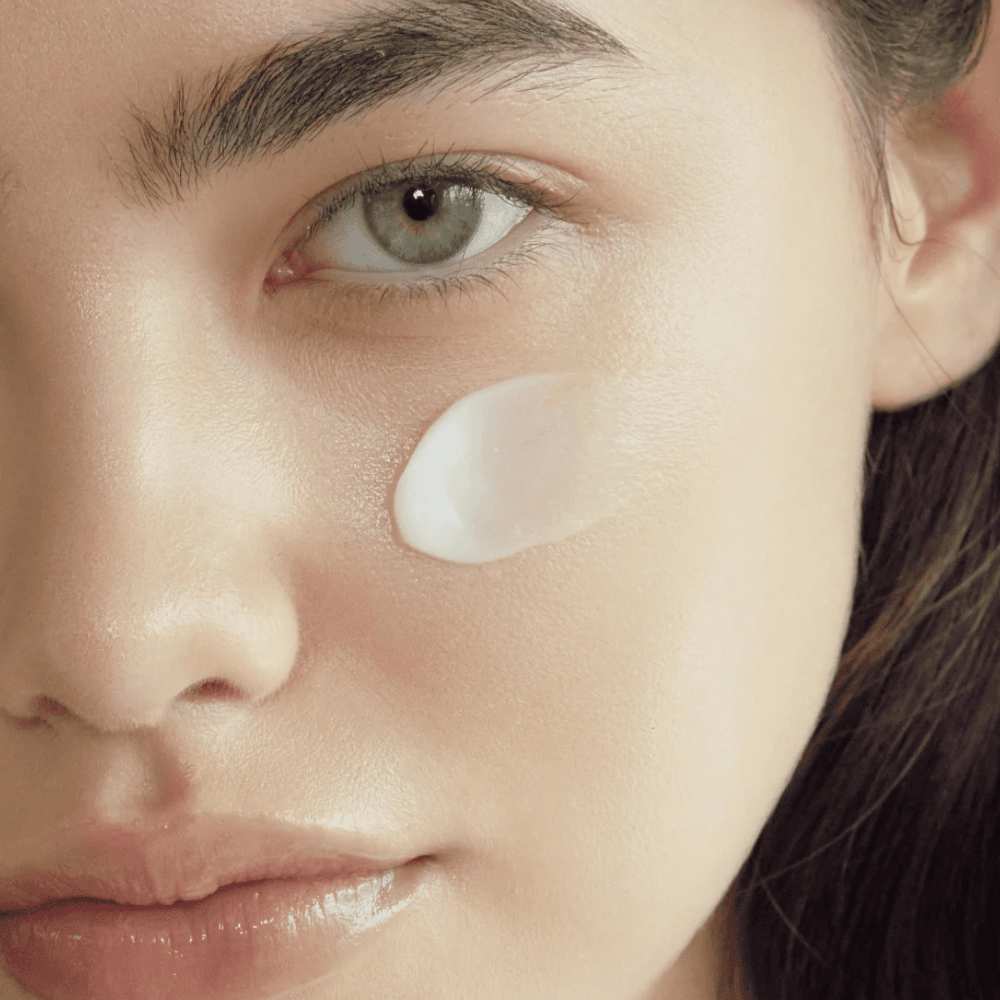 Close-up van huid met de crème aangebracht op de wang om de hydraterende, verzachtende en glowgevende finish op de huid te tonen.