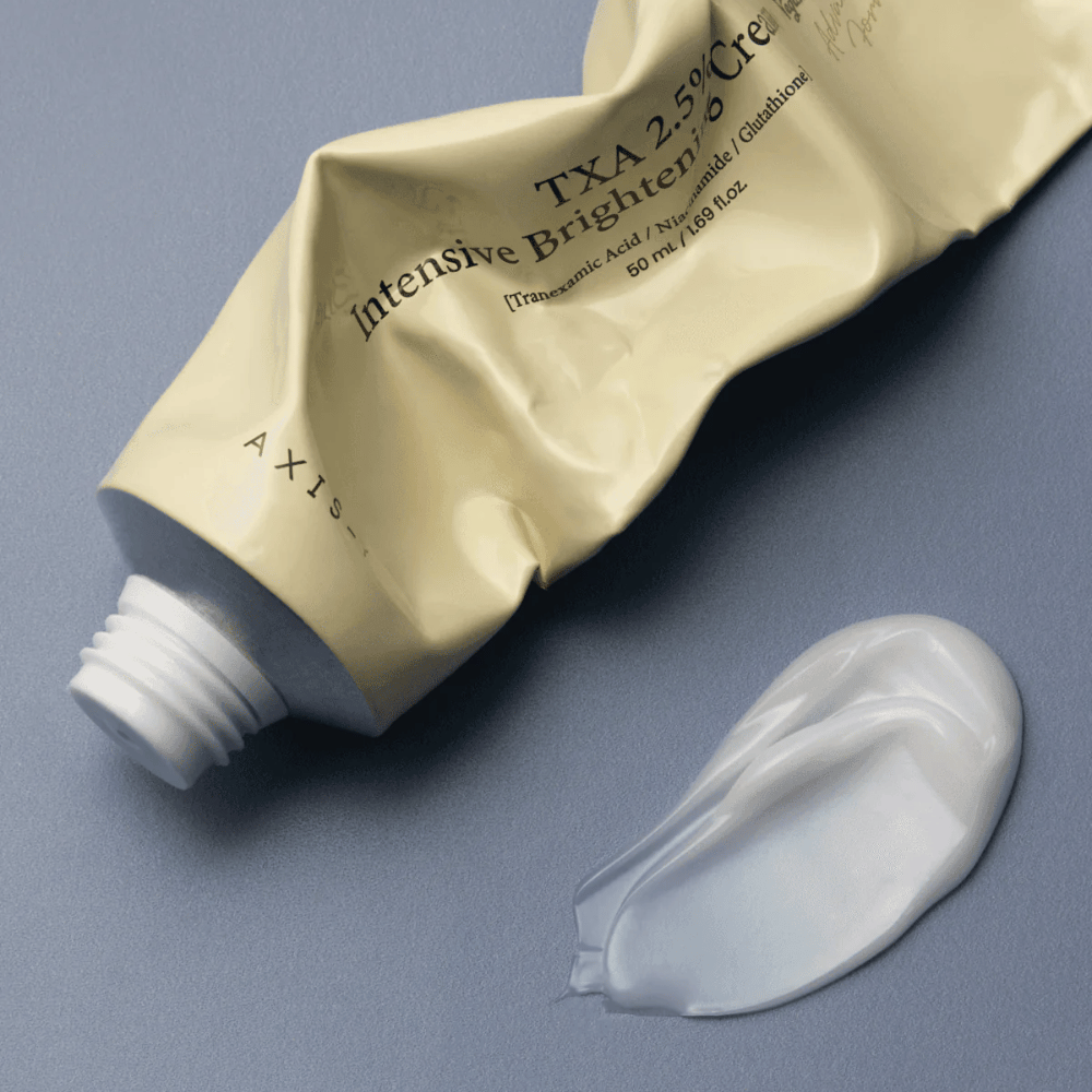 Productafbeelding met de tube en een dotje crème ernaast om de zachte, romige textuur en hydraterende formule te tonen. De focus ligt op glow en een egale applicatie.