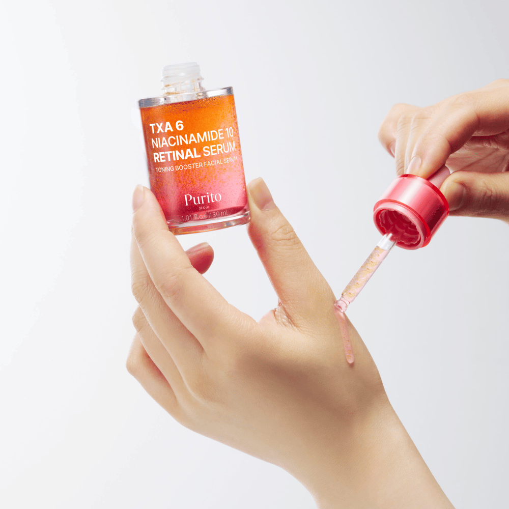 Hand past Purito TXA 6 Niacinamide 10 Retinal Serum toe. Lichte formule met actieve ingrediënten voor glans, elasticiteit en helderdere huid.