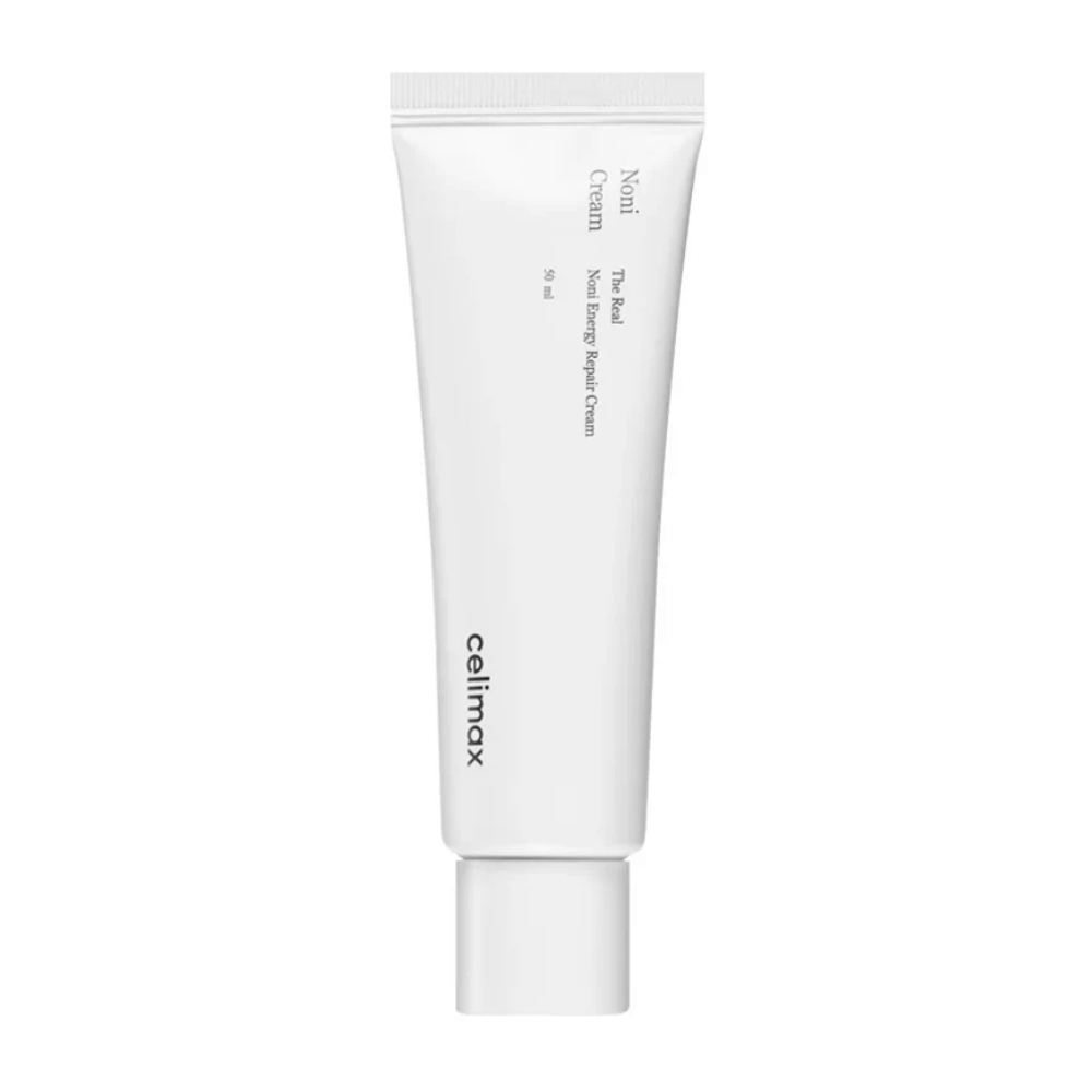 Celimax Noni Energy Repair Cream in een witte tube met zwarte tekst. Het product is gemarkeerd als "The Real Noni Energy Repair Cream" en heeft een inhoud van 50 ml.