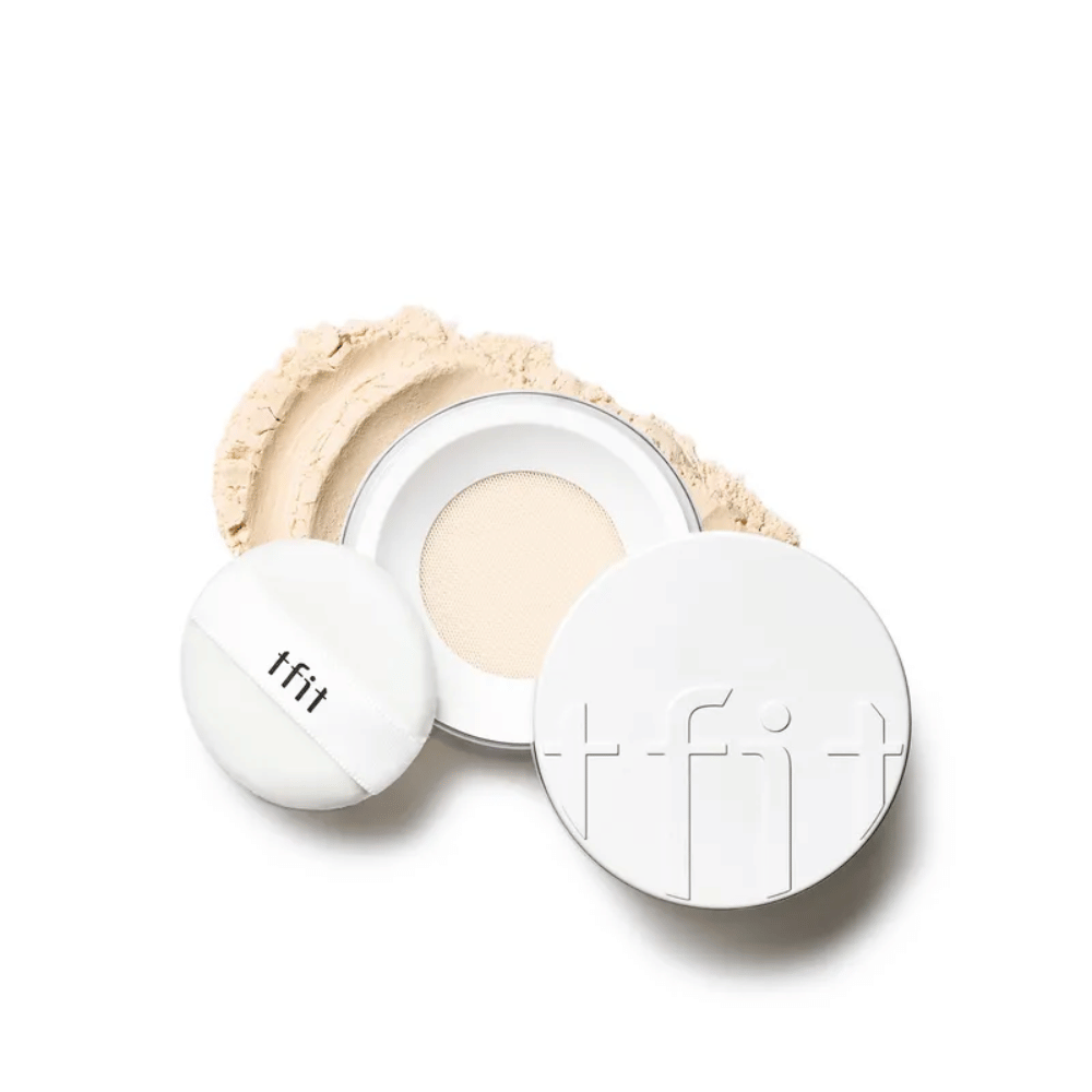 Open doos met TFIT Translucent Set Finishing Powder in de tint Skin Beige, met bijbehorende puff en setting powder verspreid rondom.
