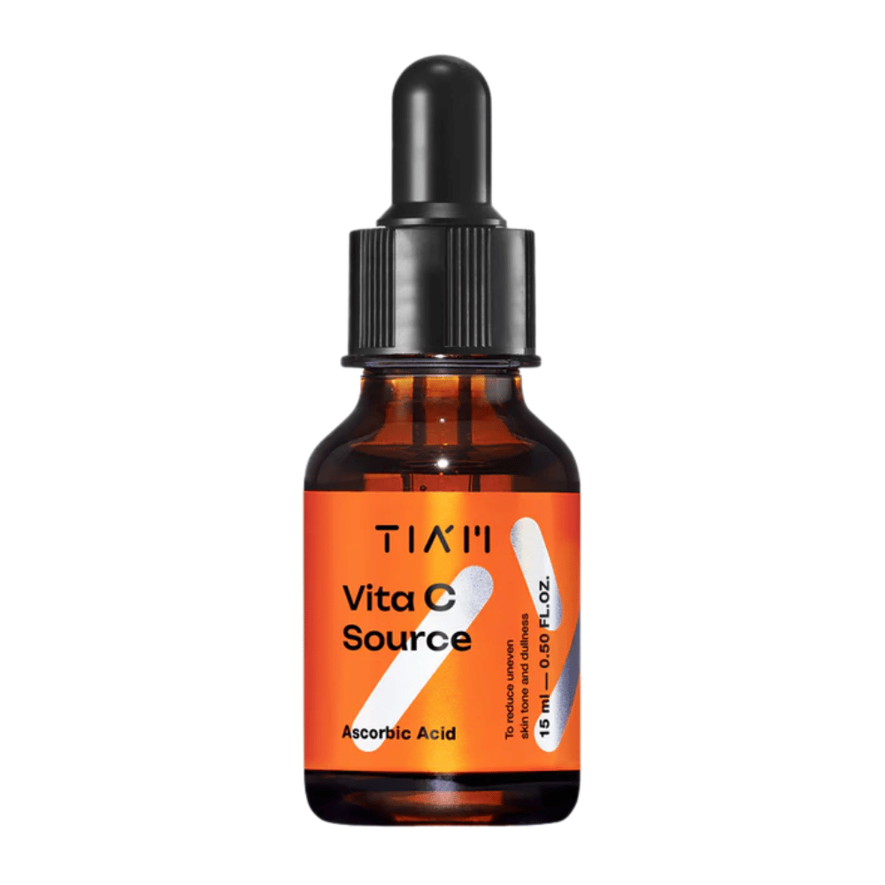 TIA'M Vita C Source, een serum met ascorbinezuur in een bruine glazen fles met zwarte pipet en oranje etiket – effectief om de huid op te lichten en een ongelijkmatige huidtint te verminderen.