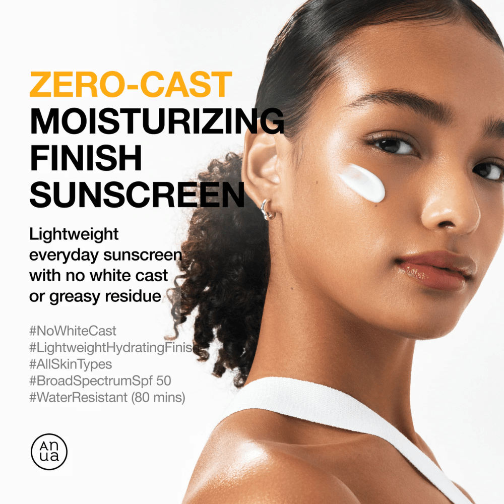 Vrouw met zonnebrandcrème op de wang toont ANUA Zero-Cast Moisturizing Finish Sunscreen - een lichte, hydraterende zonnebrandcrème met SPF 50 die geen witte waas achterlaat.