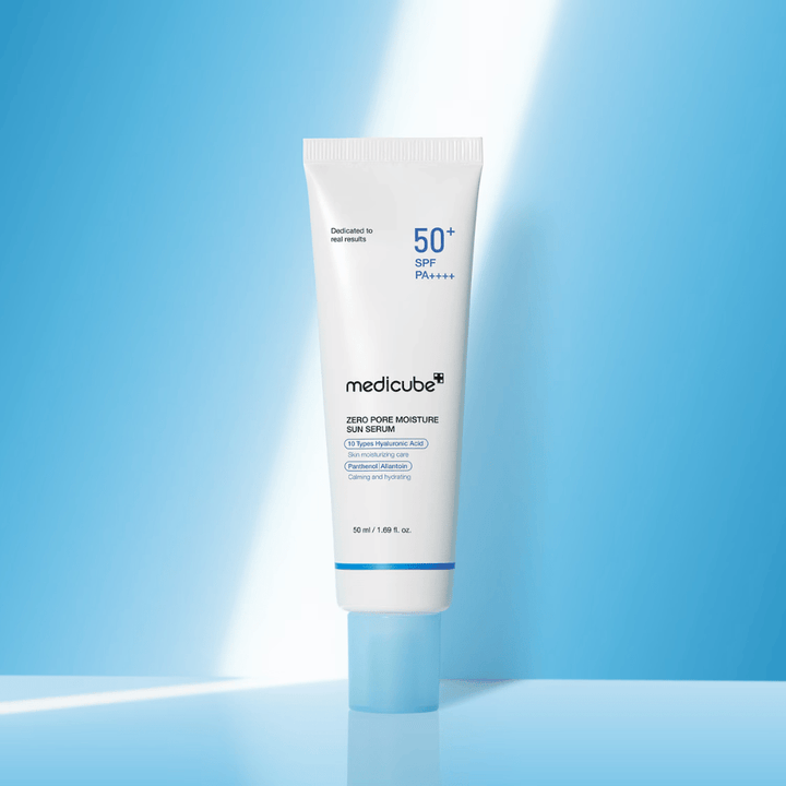 Medicube Zero Pore Moisture Sun Serum SPF50+ PA++++ gepresenteerd tegen een blauwe achtergrond. Hydraterend zonne-serum met hyaluronzuur, panthenol en allantoïne voor dagelijkse UV-bescherming en verzorging van de huid.