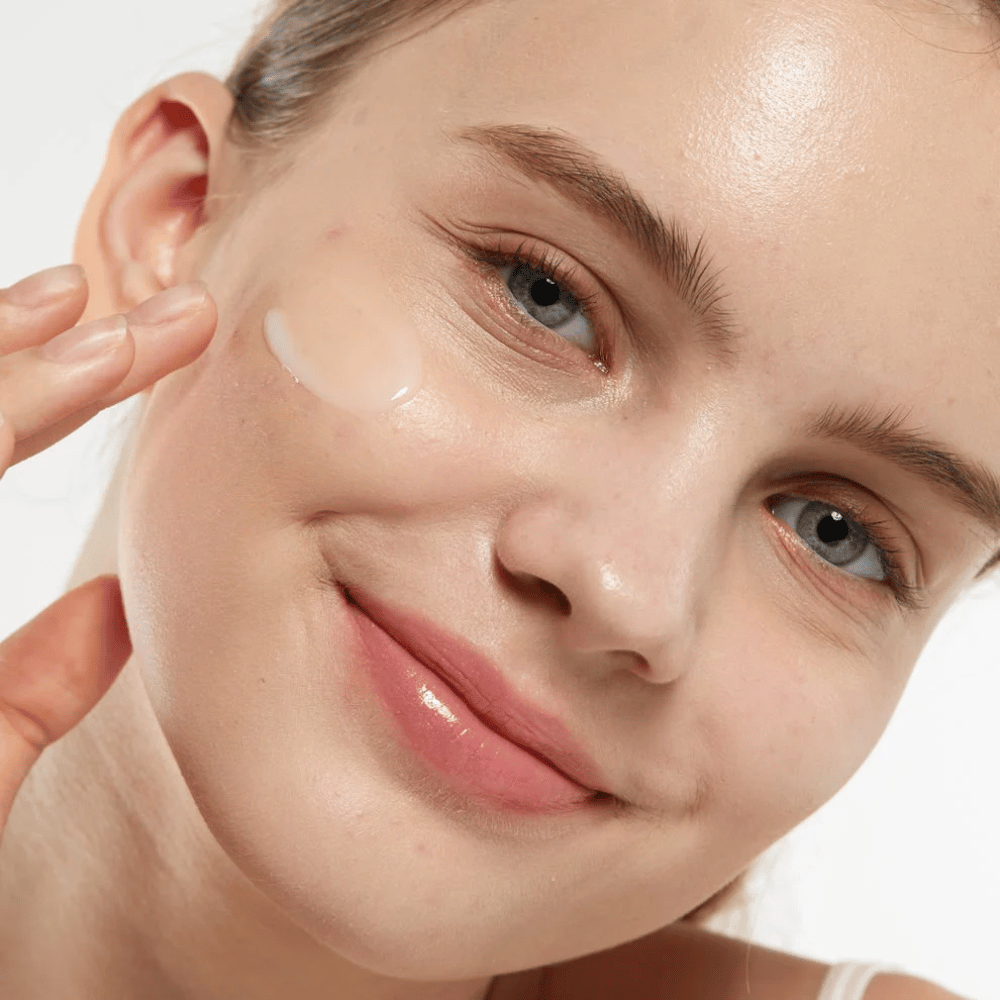 Model dat Medicube Zero Pore Serum 2.0 op de wang aanbrengt, een poriënverfijnend serum dat een gelijkmatigere huidstructuur, hydratatie en een natuurlijke glans geeft.