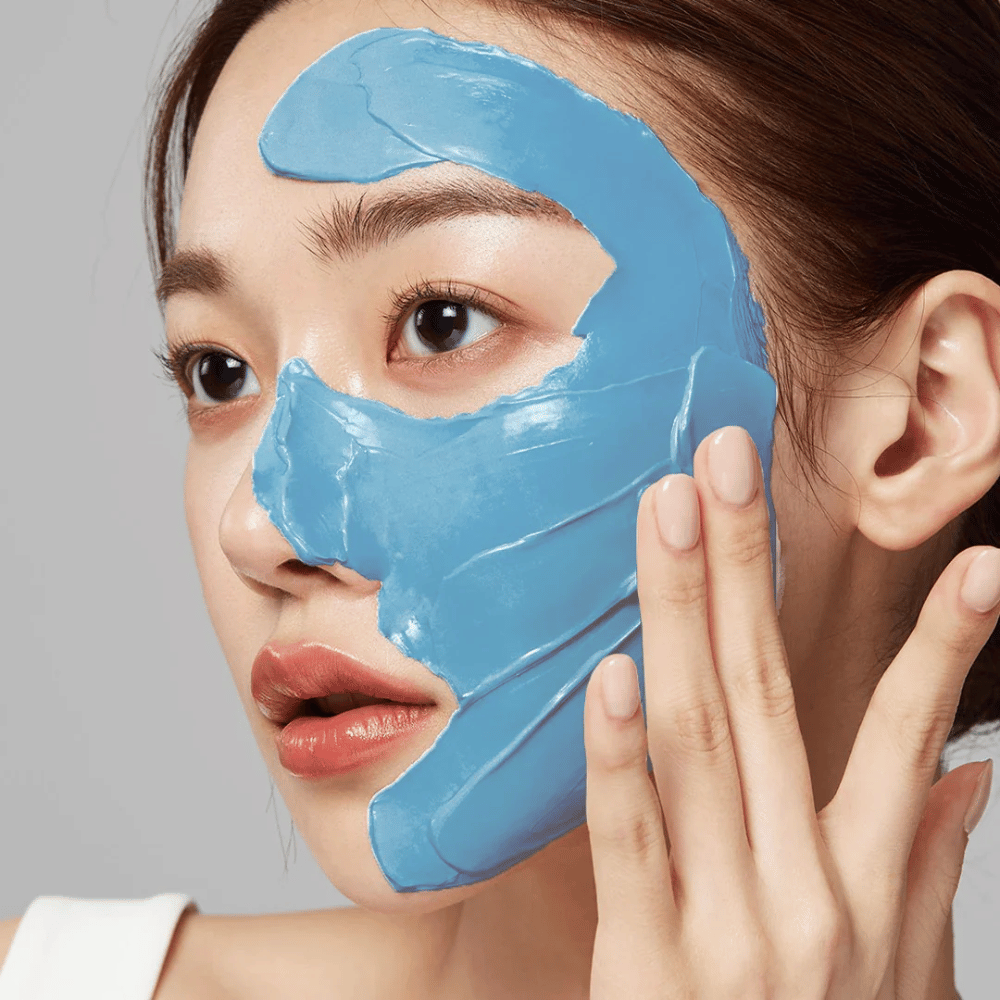 Model met blauw gezichtsmasker van Medicube, bedekt de T-zone voor porieverzorging.