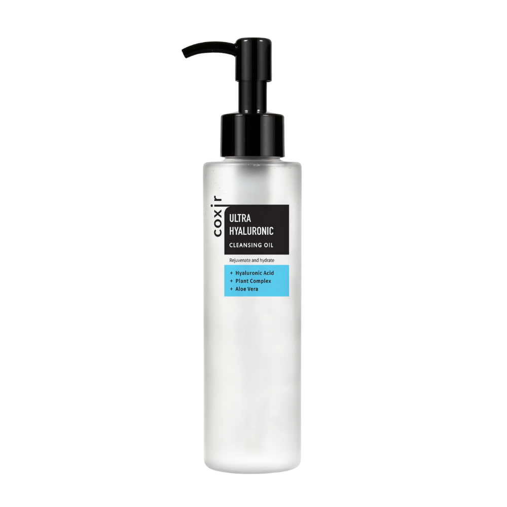Een witte pompflacon met de tekst "coxir ULTRA HYALURONIC CLEANSING OIL", bevat hyaluronzuur, plantencomplex en aloë vera voor hydratatie en zuivering.