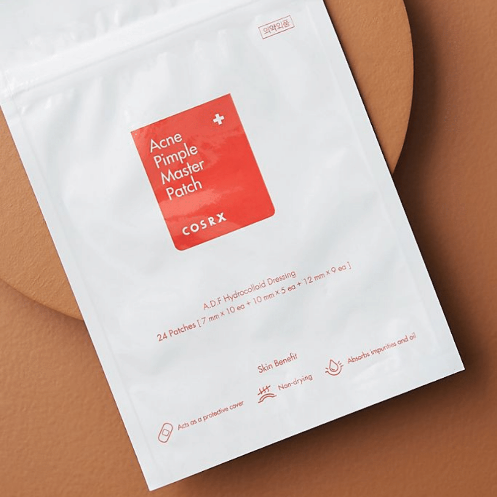 Een pakket COSRX Acne Pimple Master Patch (1pak x 24 patches) op een bruine achtergrond, met hydrocolloïdtechnologie om acne en puistjes te behandelen.