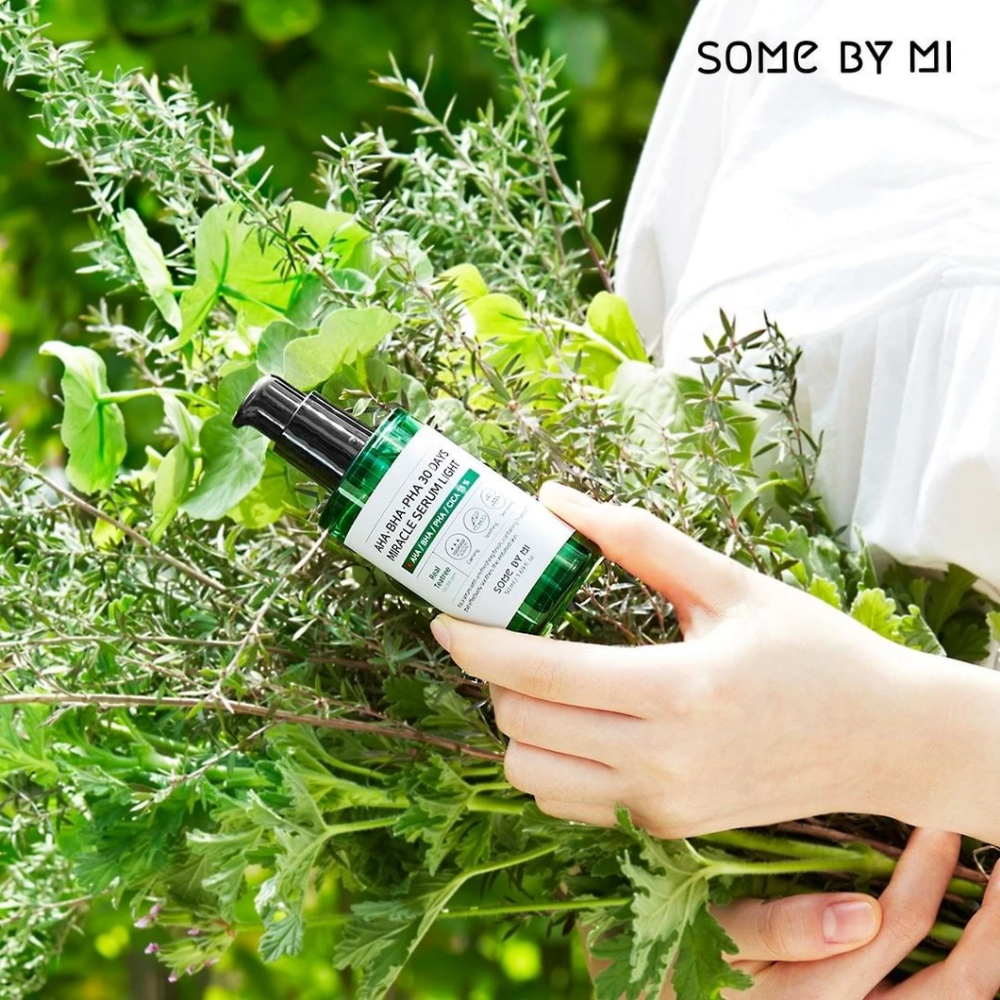 Een vrouw die een bos kruiden in haar handen houdt om pigmentvlekken en acne tegen te gaan met behulp van AHA, BHA, PHA 30 Days Miracle Serum Light 50ml van SOME BY MI.