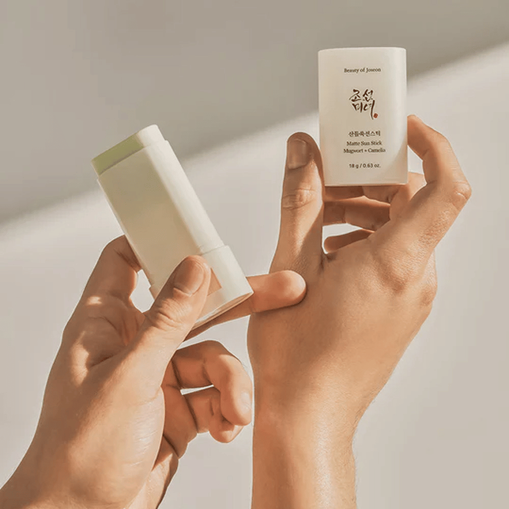 Twee handen die een stick van Beauty of Joseon's Matte Sun Stick 18g SPF50 PA++++ vasthouden.