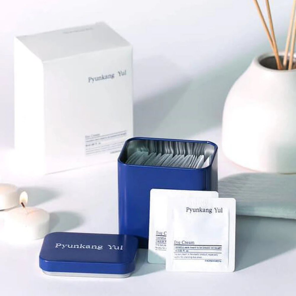 Een witte doos met blauw deksel en Pyunkang Yul Oogcrème 1ml x 50st ernaast.