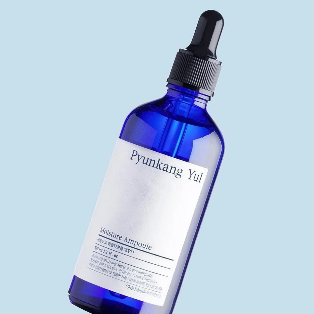 Een blauwe fles op een blauwe achtergrond met Pyunkang Yul's Moisture Ampoule 100ml serum.