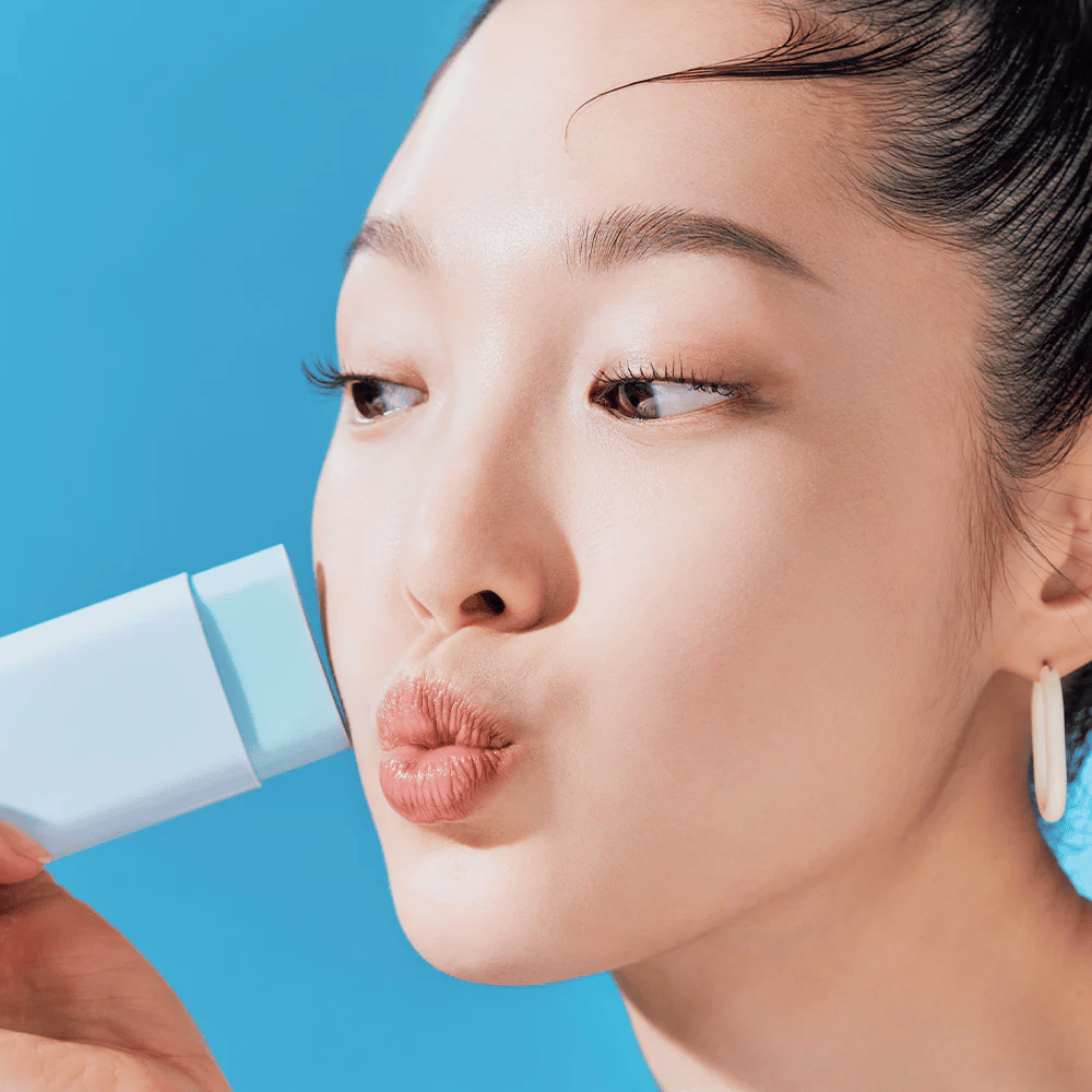 Een vrouw gebruikt een TOCOBO Cotton Soft Sun Stick SPF50+ PA++++ 19g om het gezicht te reinigen.