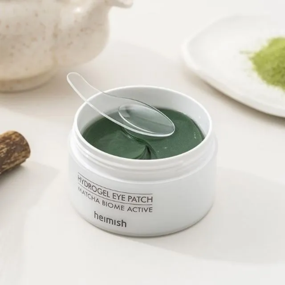 Een kom met Heimish Matcha Biome Hydrogel Eye Patch 60 pleisters met een lepel.